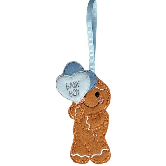Handmade felt gingerbread character with stitched details, smiling face, and two heart balloons—front balloon white with embroidered text ‘Baby Boy,’ back balloon light blue. Finished with a blue ribbon loop for hanging.