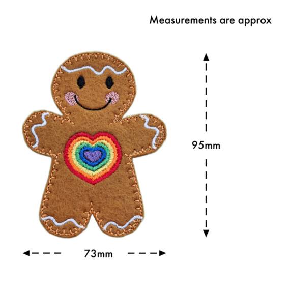 Rainbow Love Gingerbread Character — a cheerful felt gingerbread figure with a vibrant embroidered rainbow heart on its front, smiling face, and white icing details. Measurements are approximately 95mm tall and 73mm wide.