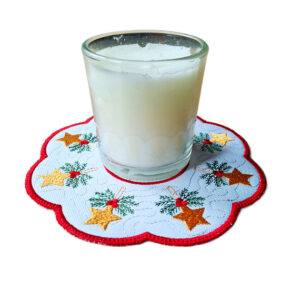 Christmas embroidered doily with golden stars and holly, shown as a decorative candle mat with white candle.
