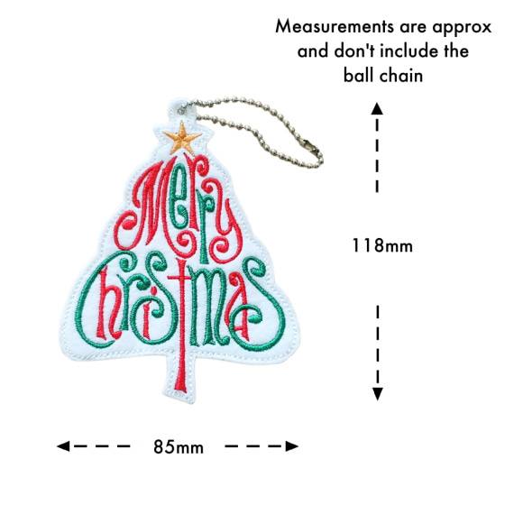 “Tree-shaped white felt ornament embroidered with the words ‘Merry Christmas’ in swirling red and green script, topped with a golden star and hanging from a silver ball chain. Shown with measurement markers indicating approximately 118mm tall and 85mm wide, not including the chain.