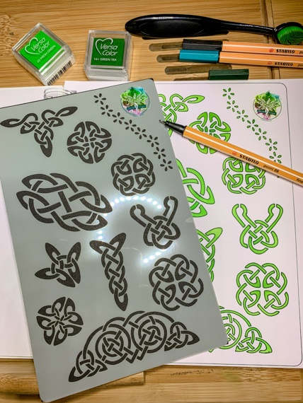 Celtic Knots Design 3 Journal Stencil - The stencil with multiple Celtic knots lays on an open journal where the right hand page shows the stencils shapes laid out in green inks, there is a pen laying across the page.