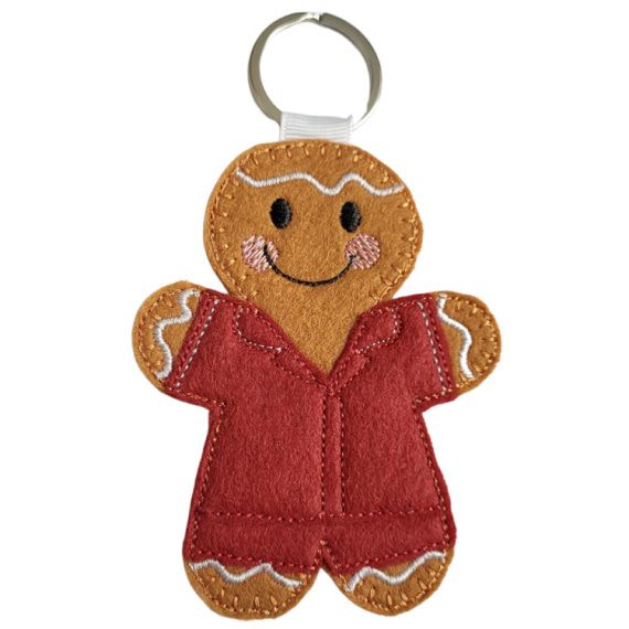 Handmade felt carer gingerbread character with embroidered features, dressed in a burgundy uniform and attached to a metal keyring.
