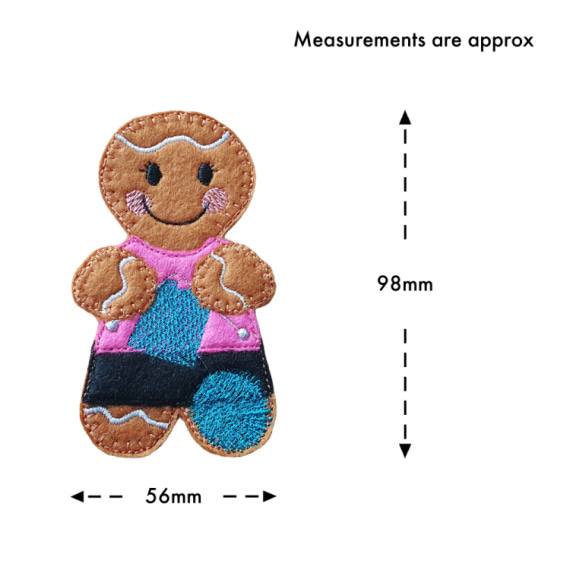 A smiling felt knitting gingerbread character with cosy stitched details, a pink top, patterned skirt, and a ball of yarn, shown with approximate measurements of 98 mm tall and 56 mm wide.