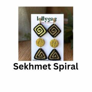 Sekhmet Spiral statement earrings in matte black and metallic gold polymer clay with spiral motifs, gold discs, and geometric drops inspired by Ancient Egyptian warrior goddess symbolism.