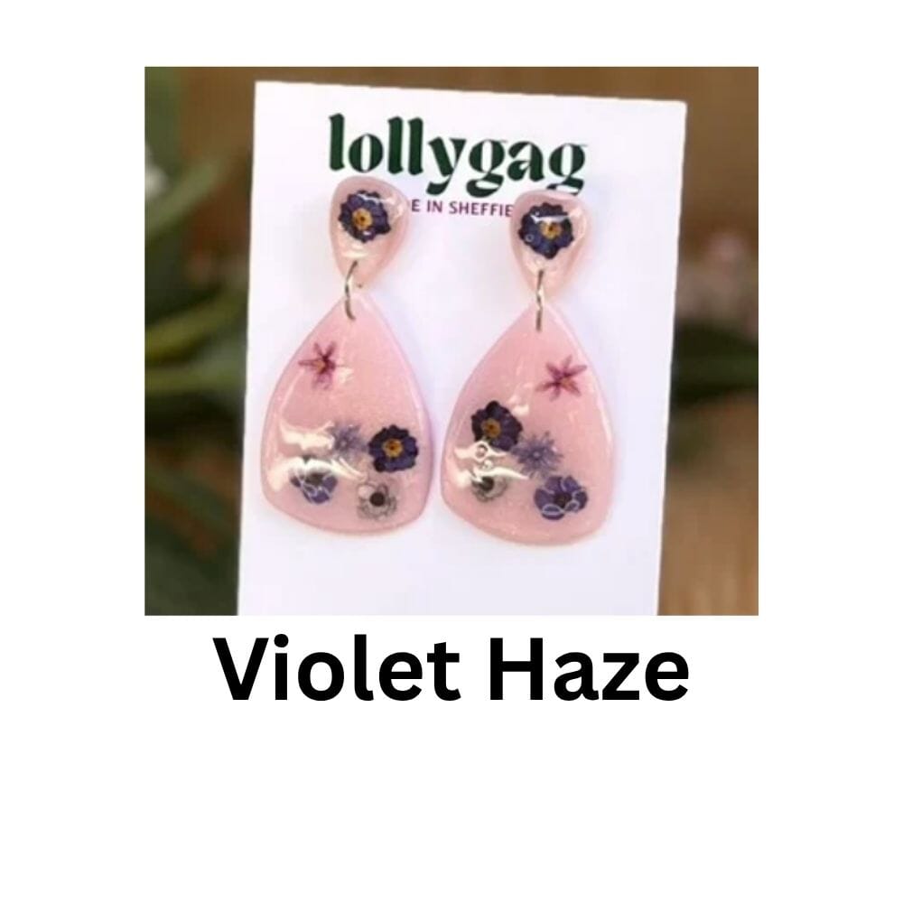 Violet Haze earrings by Lollygag Jewellery, showing pressed violet and purple flowers sealed in glossy resin over soft pink polymer clay, forming elegant drop earrings handmade in Sheffield.