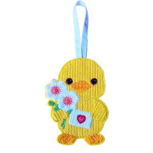 Smiling felt chick holding flowers and a small envelope with a heart, machine embroidered with a knit stitch pattern and hanging from a ribbon on a white background