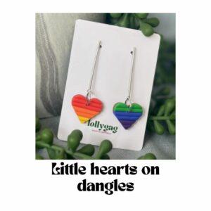 Little Hearts on Dangles Pride earrings by Lollygag featuring rainbow Pride flag colours in a small heart shape on slim stainless steel dangle bars, handmade polymer clay earrings made in Sheffield.