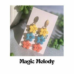 Magic Melody flower earrings by Lollygag featuring yellow, blue and coral polymer clay flowers in a cascading design, lightweight handmade 90s-inspired earrings made in Sheffield.