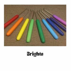 Custom loom hooks with smooth plain colour polymer clay handles in bright rainbow shades, including red, orange, yellow, green, blue and purple, arranged on a wooden surface.