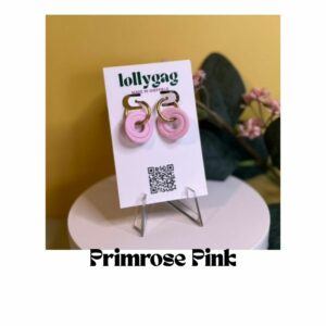 Handmade polymer clay spiral hoop earrings in Primrose Pink, inspired by the Pantone Autumn Winter palette, displayed on a Lollygag jewellery card with gold-tone hoops against a warm yellow background.