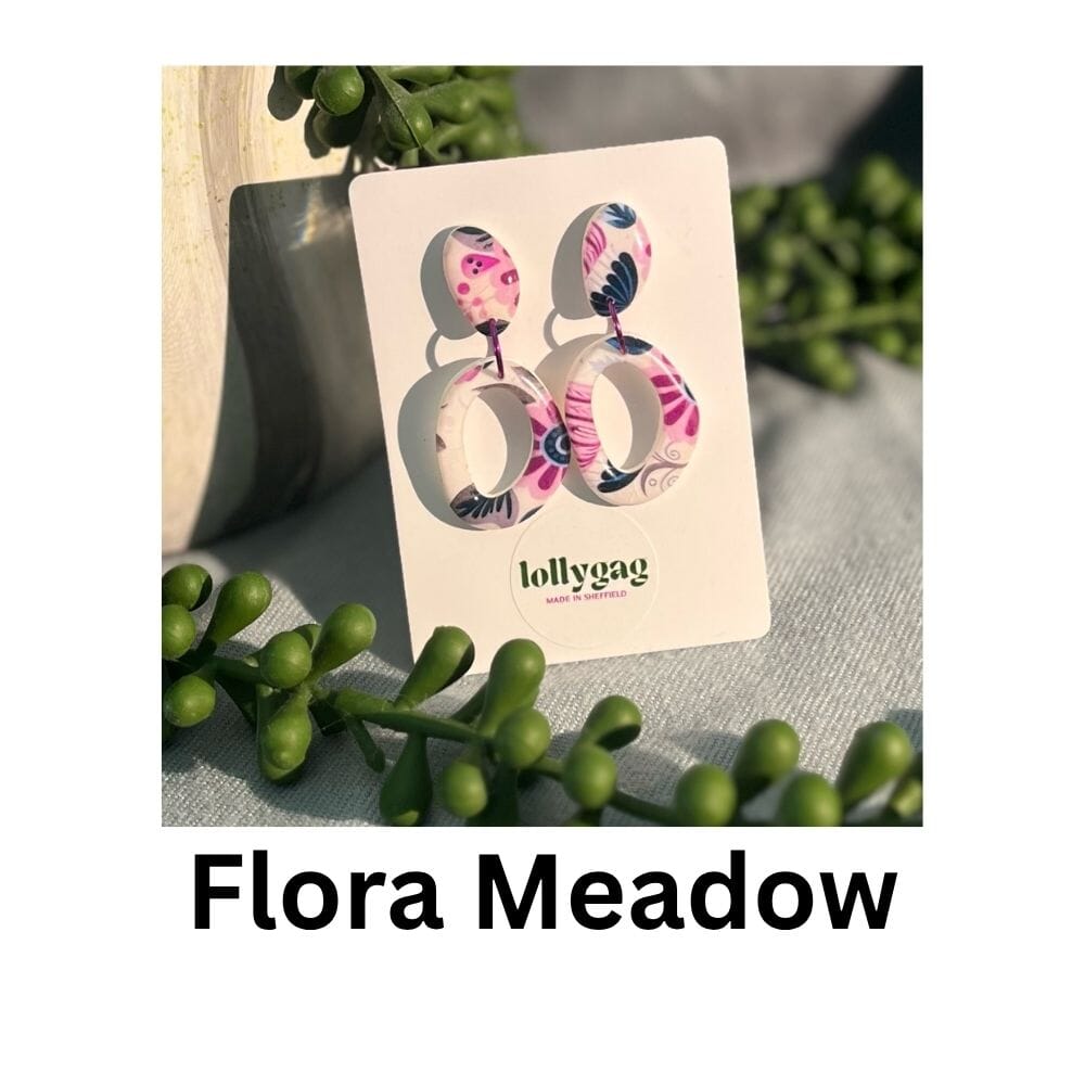 Flora Meadow loop earrings featuring large sculptural polymer clay hoops decorated with pink and blue 1970s floral wallpaper patterns, handmade by Lollygag Jewellery.