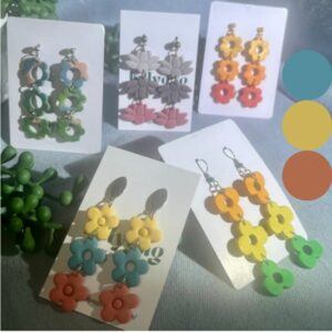 Magic Number Collection handmade flower earrings by Lollygag displayed as a group, featuring bright 90s-inspired polymer clay flower earrings in yellow, blue, green, peach and red tones, dopamine dressing jewellery handmade in Sheffield.