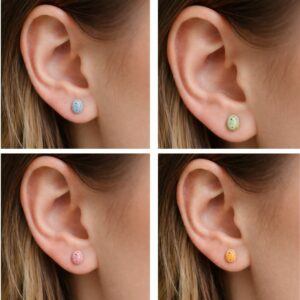 Handmade polymer clay micro stud earrings shaped like pastel speckled mini eggs in blue, green, pink and yellow, worn in ear close-up, lightweight Easter inspired jewellery handmade in Sheffield UK.