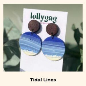 Tidal Lines handmade polymer clay earrings with layered blue ocean wave patterns and sandy shore detail, finished with wooden stud tops, by Lollygag in Sheffield.