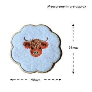 Round scalloped Highland cow candle coaster in white fabric with central embroidered cow head, shown with measurement guide indicating approximately 98mm width and 98mm height.