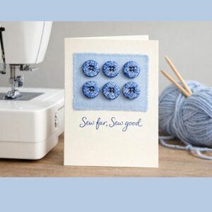 Handmade sewing pun button card displayed beside a sewing machine, knitting needles, and blue wool, featuring six reusable polymer clay buttons and the phrase Sew far, sew good.