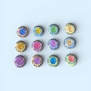 Set of 12 handmade Blob Says glass cabochon fridge magnets featuring colourful smiling blob faces with positive affirmations including You Are Capable, You Are Enough and You Are Strong, arranged on a soft blue background.