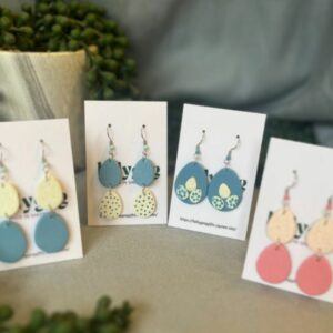 Handmade Easter egg polymer clay earrings in pastel blue, yellow and pink, displayed on Lollygag cards, Sheffield made spring statement jewellery.