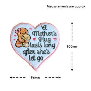 Embroidered felt heart decoration with the message 'A Mother’s Hug Lasts Long After She’s Let Go' and a mum and child gingerbread illustration, shown with approximate measurements of 100mm tall and 96mm wide.