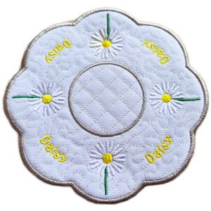 Embroidered daisy candle mat with scalloped edge, featuring white daisies with yellow centres and green stems on a white background, with a circular space in the centre for a candle.