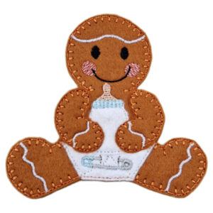 A felt gingerbread baby decoration with stitched details, smiling face, rosy cheeks, and white icing accents. The gingerbread is wearing a white nappy with an embroidered pin and holding a small baby bottle with a blue top.
