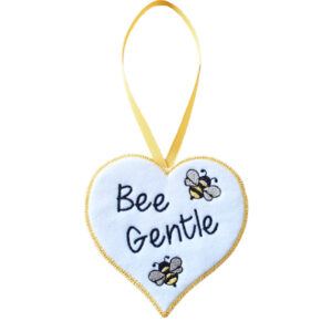 Embroidered white felt heart with the words ‘Bee Gentle’ and two yellow and black bees, bordered in yellow with a yellow ribbon loop for hanging. Handmade decoration perfect for walls, shelves, or door handles.