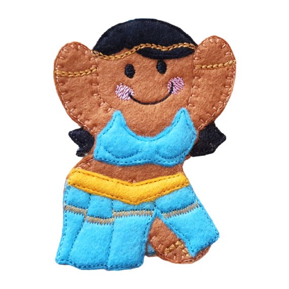 A smiling felt gingerbread girl dressed as a belly dancer, with raised arms, black hair, a turquoise stitched top, and a flowing turquoise skirt with a yellow belt.