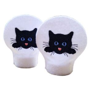 Two embroidered tealight covers made from soft felt, each featuring a black cat face with blue eyes and a pink nose on a white background, shown fitted over flameless tealights.