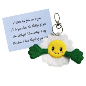 Embroidered daisy pocket hug charm with a smiling yellow face and green outstretched arms, made from soft felt. Displayed with a keepsake poem card that reads: ‘A little hug from me to you, to let you know I’m thinking of you. And although I have nothing to say, you know I have thought of you today’