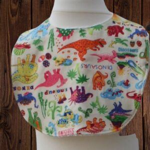 Dinosaur Bib lots of friendly dinosaurs in bright colours green, orange and blue etc