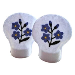 Set of two embroidered Forget Me Not tealight covers made from white felt, featuring blue flowers symbolising love and remembrance, designed for LED tealights.