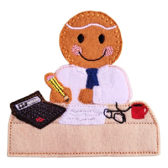 Felt gingerbread accountant character seated at a small desk with papers, glasses, a calculator, a pencil, and a hot mug, with neat embroidered details and a smiling face.