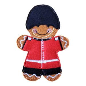 Grenadier Guard Gingerbread Character made from soft felt, wearing a red uniform and tall black bearskin hat, with embroidered details.