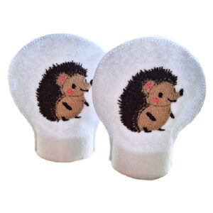 Two white tealight covers featuring embroidered hedgehogs with brown spines and pink cheeks, shown as a matching set designed to fit over standard LED tealights for a woodland-themed decorative touch.