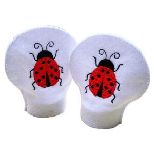 Two white felt tealight covers featuring bright red embroidered ladybirds with black spots and antennae, displayed standing upright on a white background.