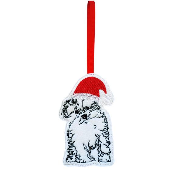 Handmade felt Maltese dog ornament with machine embroidered detail, wearing a red Santa hat and hanging from a red ribbon loop.