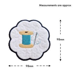 Embroidered needle and thread candle coaster with scalloped edge, showing approximate size of 98mm by 98mm, featuring a spool of thread and stitched detail on a white background.