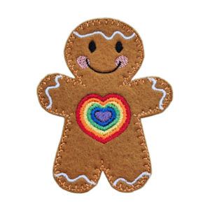 Handmade felt gingerbread character with stitched icing details and a smiling face, featuring a rainbow heart design on the chest.