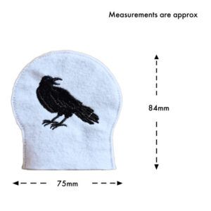 Embroidered raven tealight cover in white felt, designed to fit over an LED tealight, featuring a black raven silhouette, with approximate measurements of 84mm by 75mm.