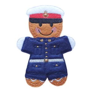 Handmade felt gingerbread character dressed as a Royal Marine, featuring a blue uniform with embroidered details and a white peaked cap with a red band.