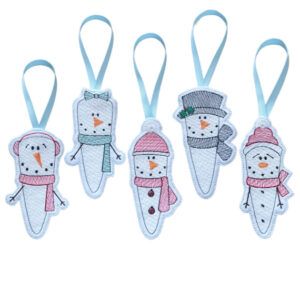 Set of five handmade felt icicle snowman ornaments, each machine embroidered with different winter accessories including hats, scarves and earmuffs, hanging from pale blue ribbon loops.