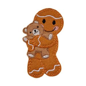 A handmade gingerbread character holding a small teddy bear, with stitched facial details and a warm, cheerful expression. The design conveys comfort, love, and togetherness, suitable as a decorative keepsake or gift.