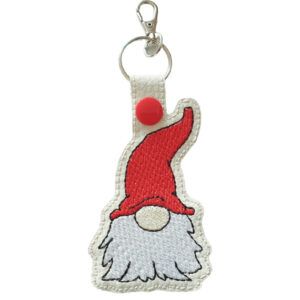 Woodland gnome keyring made from faux leather, featuring a small embroidered gnome with a long white beard and a tall red hat, attached to a silver keyring clip.