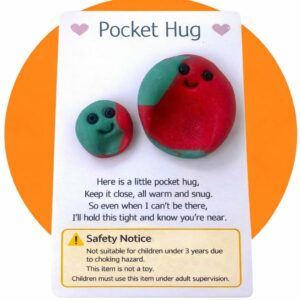 Two handmade polymer clay pocket hug worry stones on a card titled “Pocket Hug” with comforting poem and visible safety warning stating not suitable for children under 3 years due to choking hazard and not a toy
