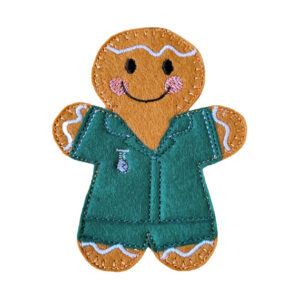 A felt gingerbread figure wearing a green veterinary nurse uniform, with embroidered details, a smiling face, and pink cheeks.