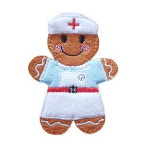 Handmade felt gingerbread character dressed as a nurse, featuring a light blue uniform, white apron, and a white nurse’s cap with a red cross, with embroidered icing details and a smiling face.