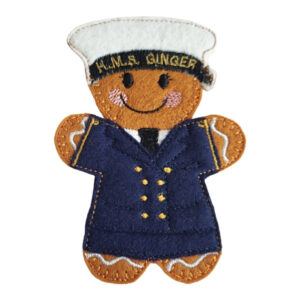 WREN Sailor Gingerbread Character made from soft felt, wearing a navy-blue uniform with gold button details and a white sailor cap embroidered with ‘HMS Ginger’, celebrating the women of the Women’s Royal Naval Service.