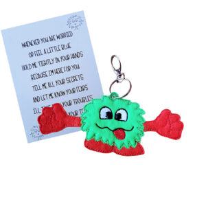 Worry Monster Pocket Hug Charm – A cute green and red felt monster with outstretched arms and a smiling face, holding a keepsake card with a comforting poem. A handmade keyring or bag charm designed to chase away worries and bring comfort.