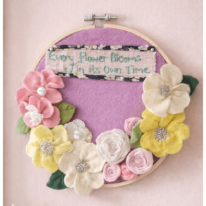 Felt Flower adorned Embroidery Hoop Art with caption ‘Every flower blooms in its own time.’