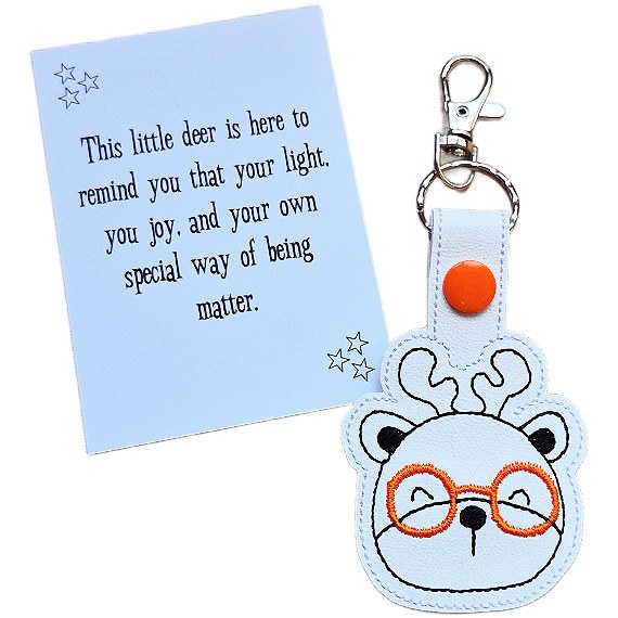 Deer face keyring with orange glasses shown with matching keepsake card featuring an uplifting message.